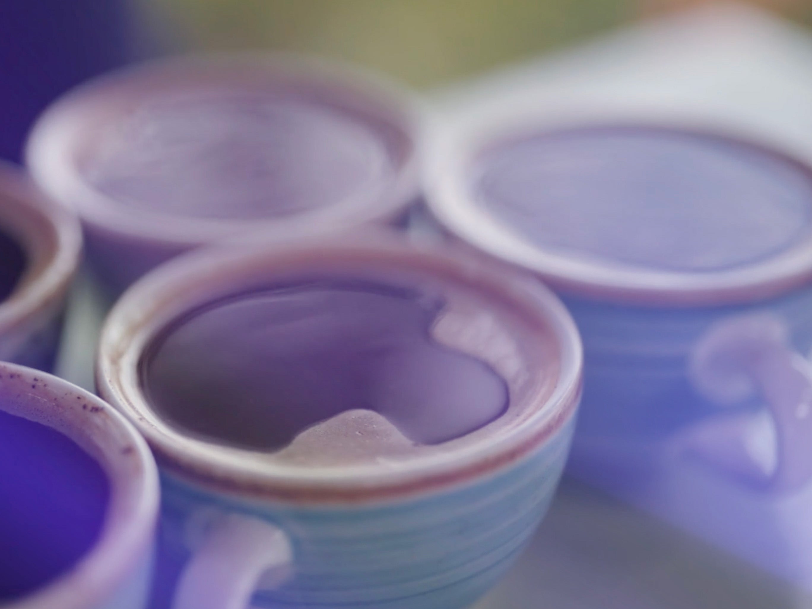 Close-up of ceramic pots with purple interior glaze on a blurred background