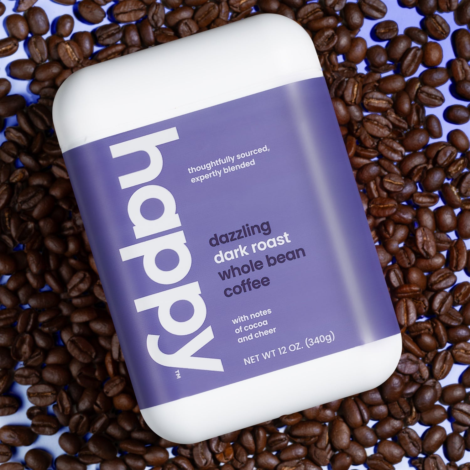 Whole Bean Dazzling Dark Roast Coffee container resting on a bunch of coffee beans