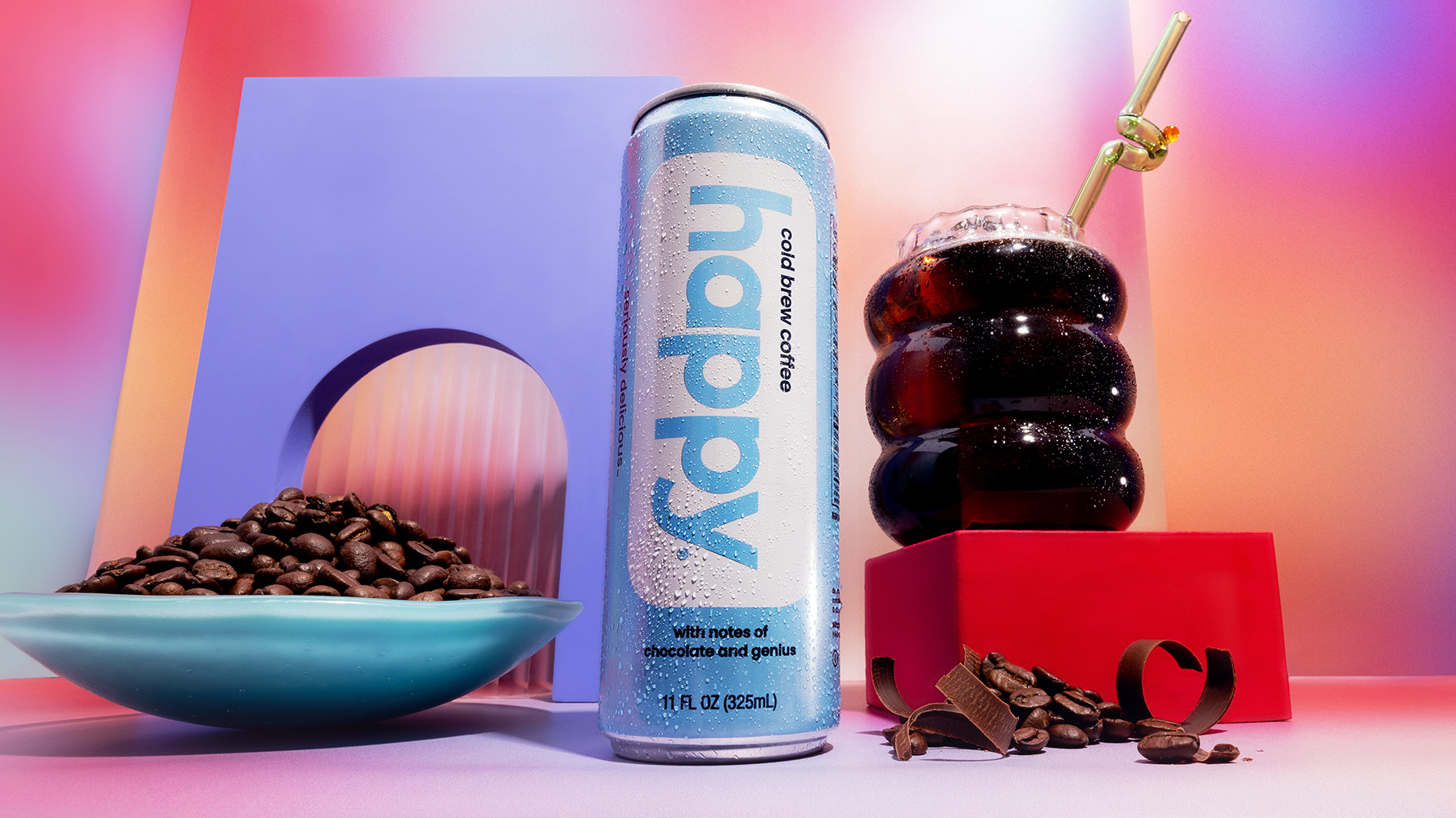 Can of 'happy' cold brew coffee with coffee beans and a drink on a colorful background