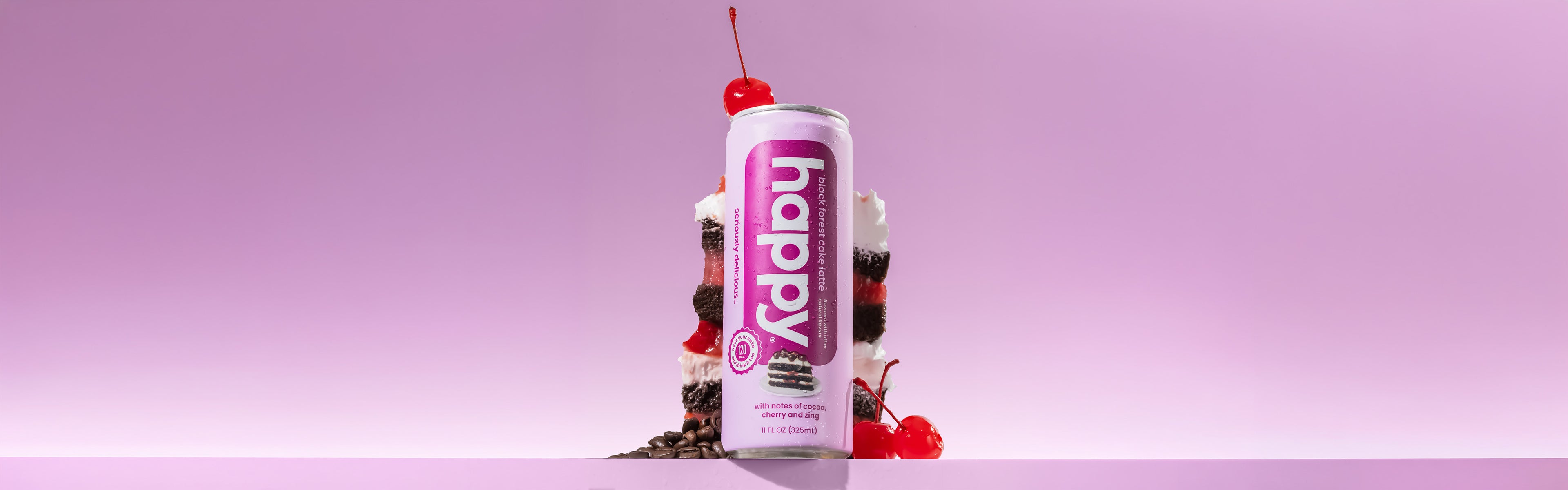 Can of 'happy black forest cake latte with a cake on a purple background