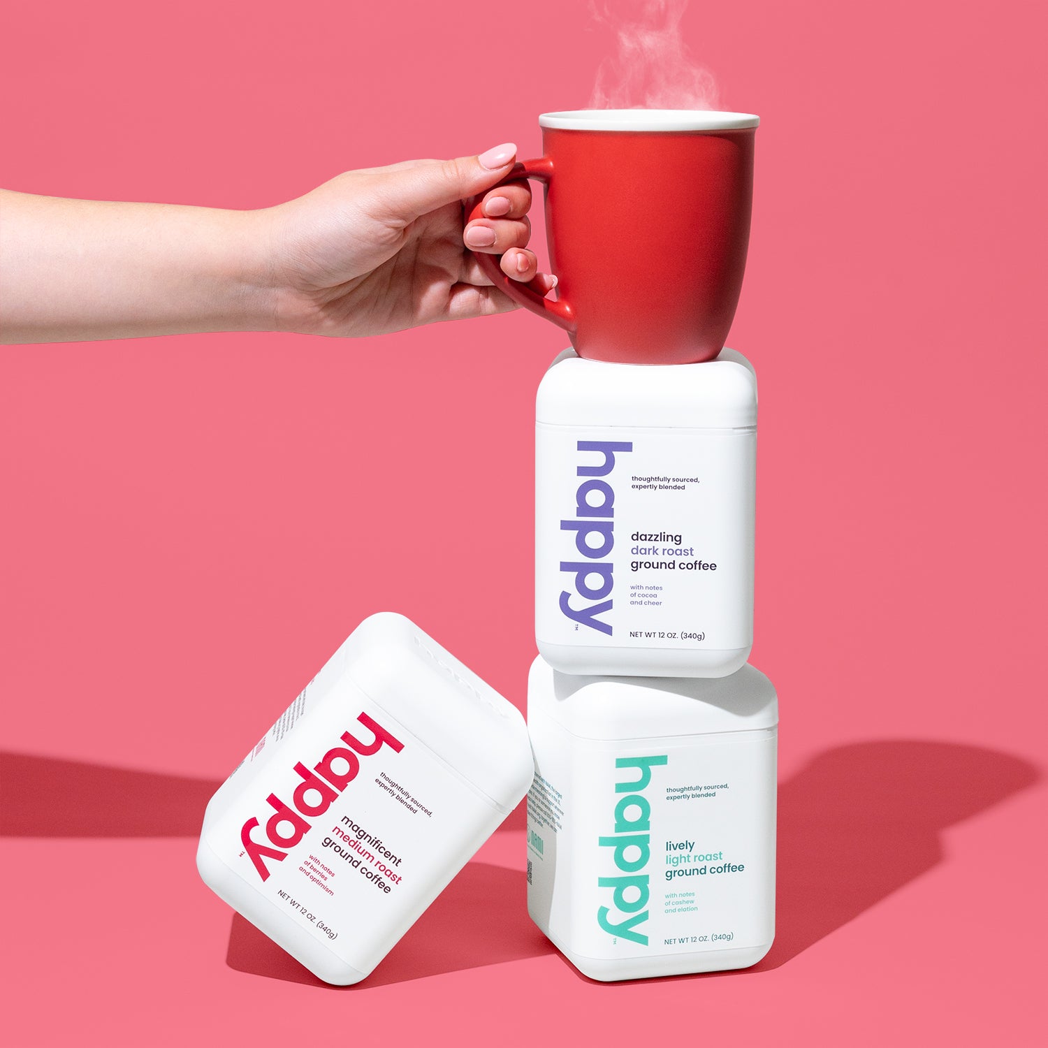 3 stacked cubes of a variety of happy coffee roasts with a red mug on top. 