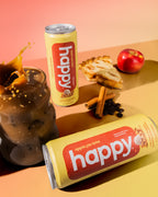 Two cans of 'happy' apple pie latte on a colorful background with coffee and apples.