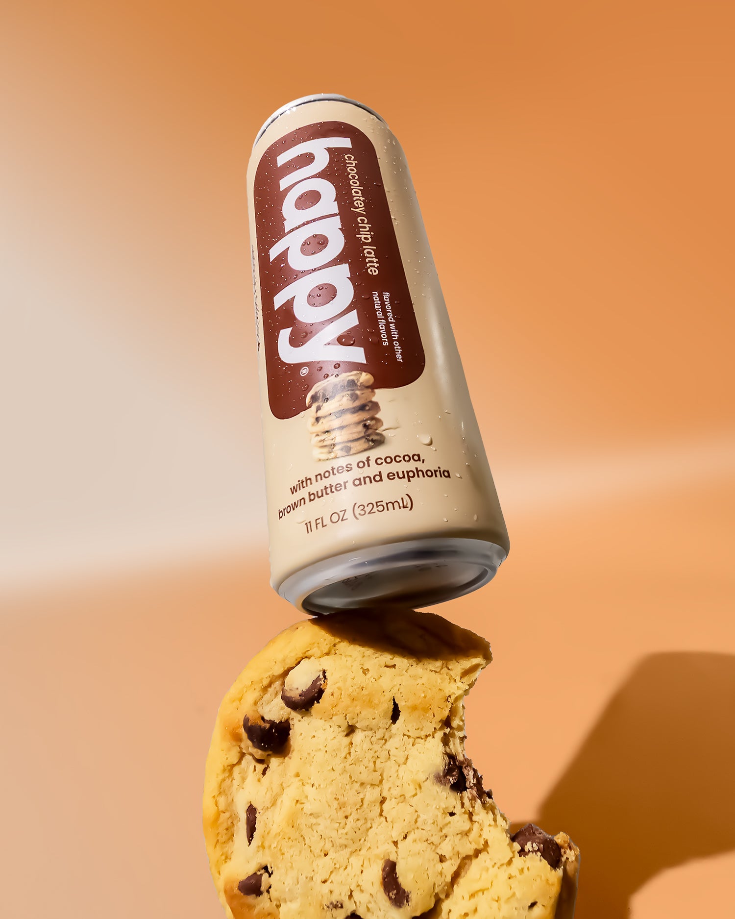 Can of 'happy' chocolatey chip latte on a cookie with an orange background