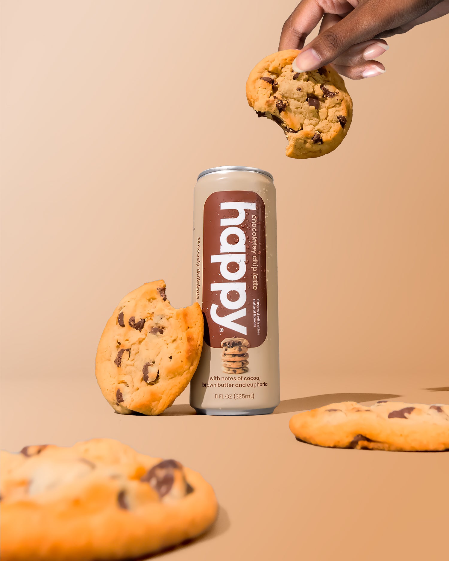 Can of 'happy' Chocolatey Chip Latte with chocolate chip cookies on a beige background
