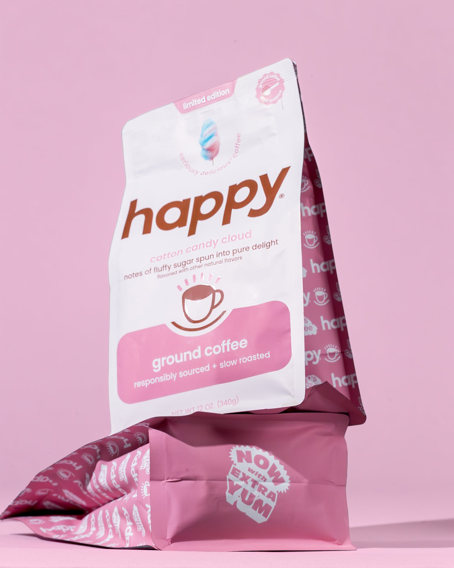 Two bags of happy cotton candy cloud ground coffee stacked on top of each other with a pink background