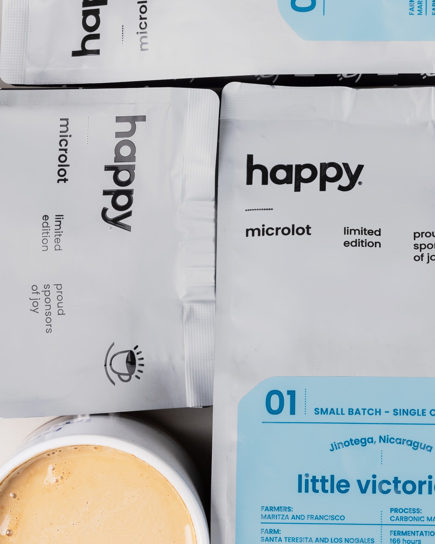 Happy microlot coffee packages with a small batch coffee container in the foreground.