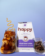 Happy whole bean coffee package with iced coffee and coffee beans on a blue background