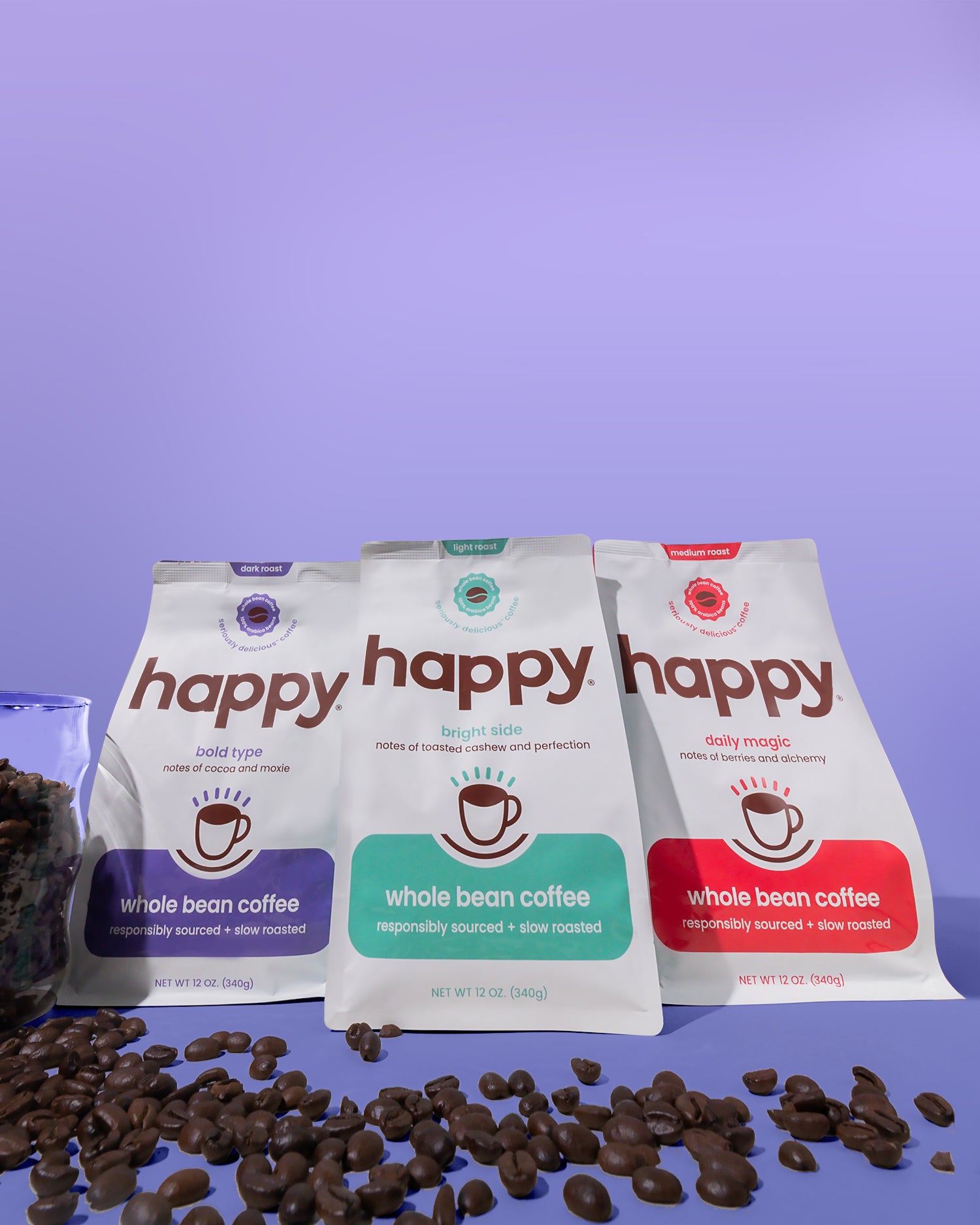 Three 'happy' brand whole bean coffee packages with coffee beans on a purple background