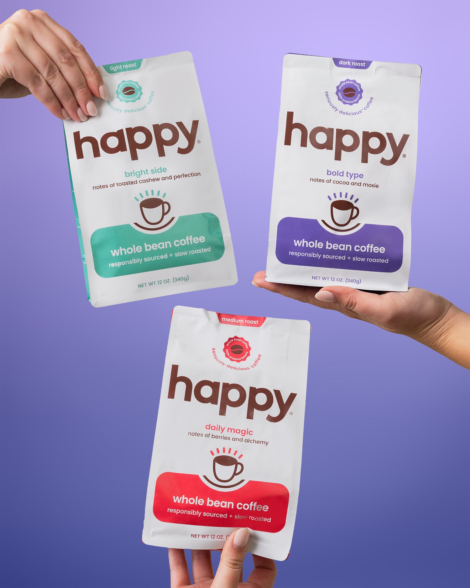 Three 'happy' brand whole bean coffee packages held by hands against a purple background