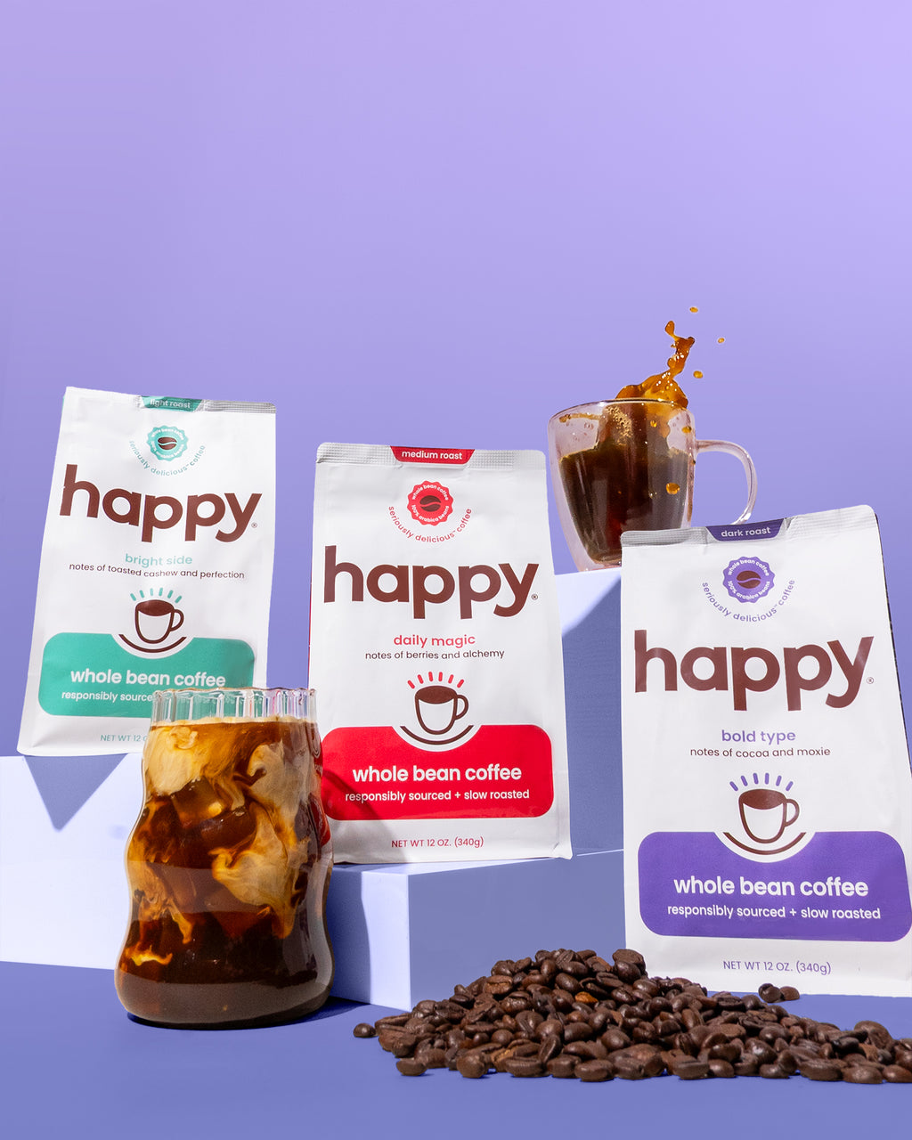 Three packages of 'happy' coffee with a cup of coffee and coffee beans on a purple background
