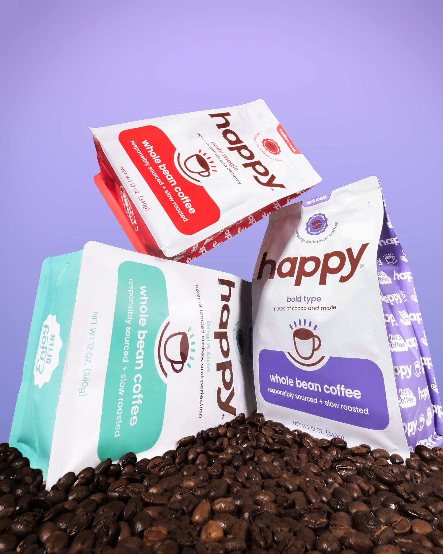 Three 'happy' brand coffee packages on a bed of coffee beans with a purple background