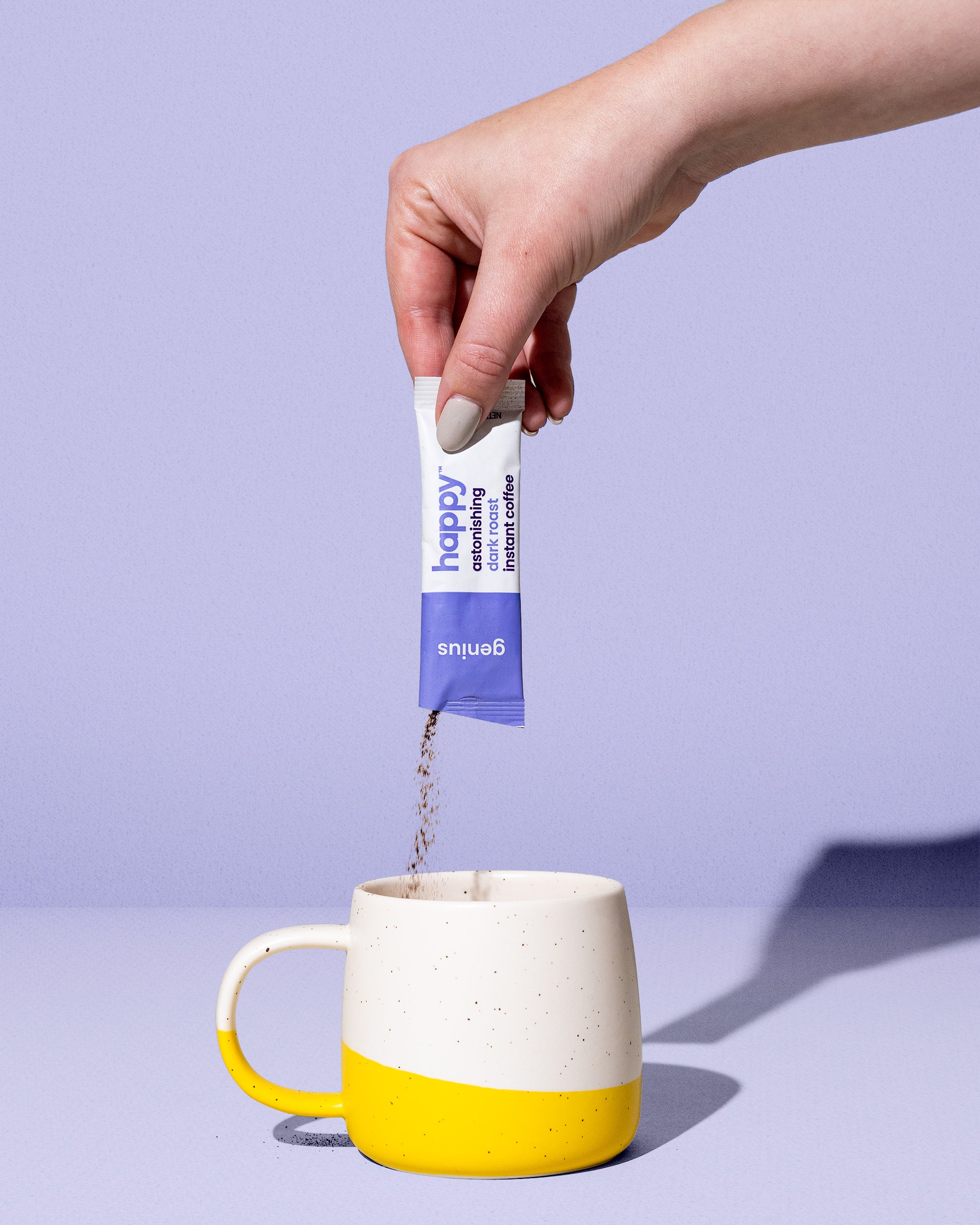 a sachet of astonishing dark roast instant coffee being poured into a coffee mug