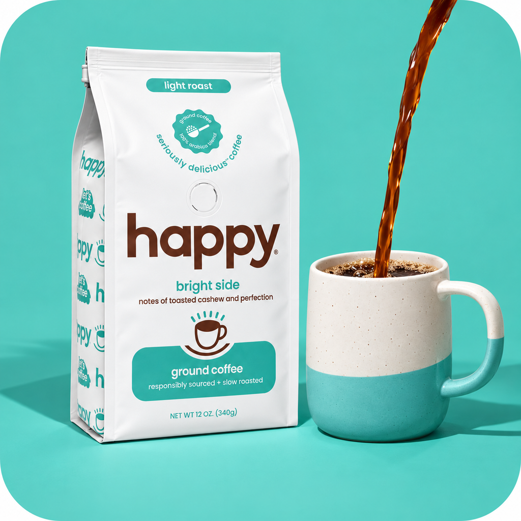A bag of Happy Bright Side light roast ground coffee stands next to a white and teal ceramic mug with coffee being poured into it, set against a solid teal background.