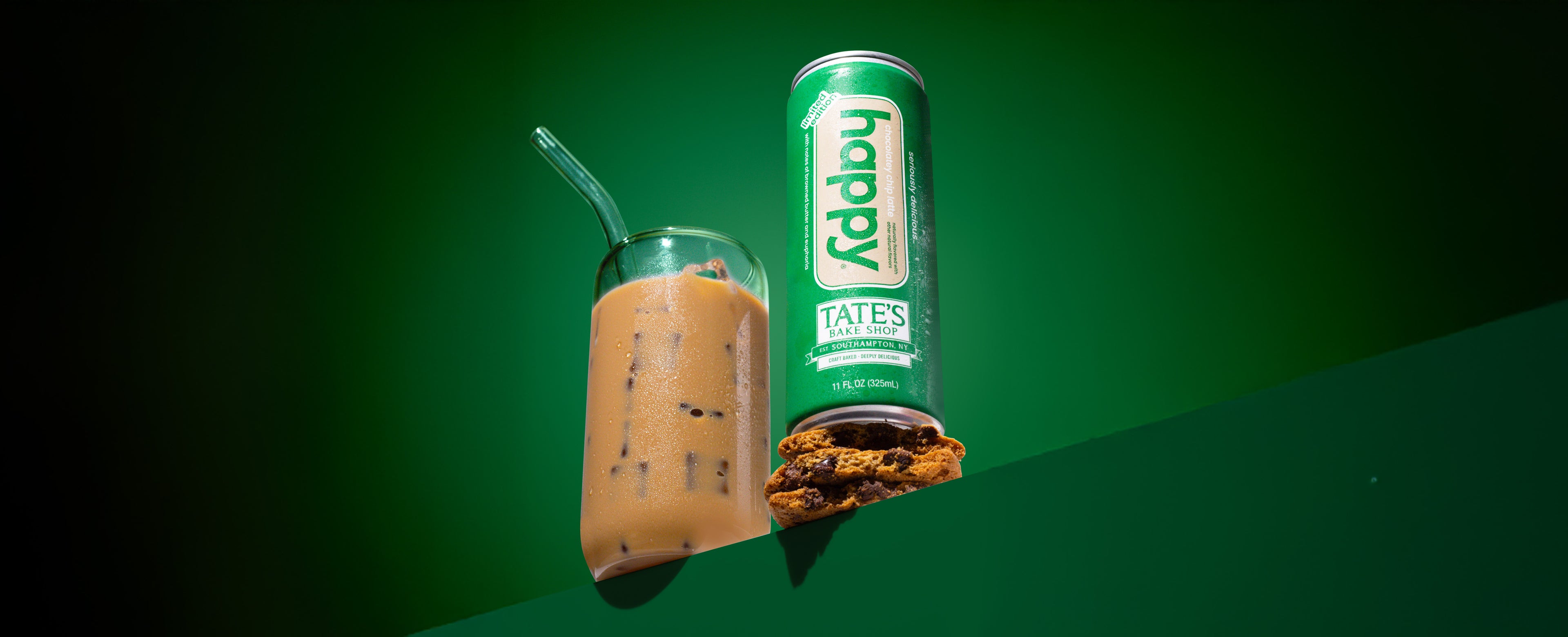 happy ready to drink chocolatey chip Tate's latte sitting on a stack of chocolate chip cookies next to a glass of iced mocha latte
