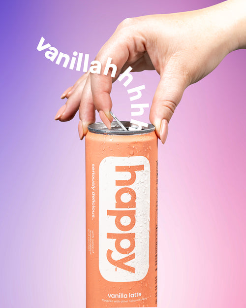 Hand holding a can of 'happy' vanilla latte against a gradient purple and pink background